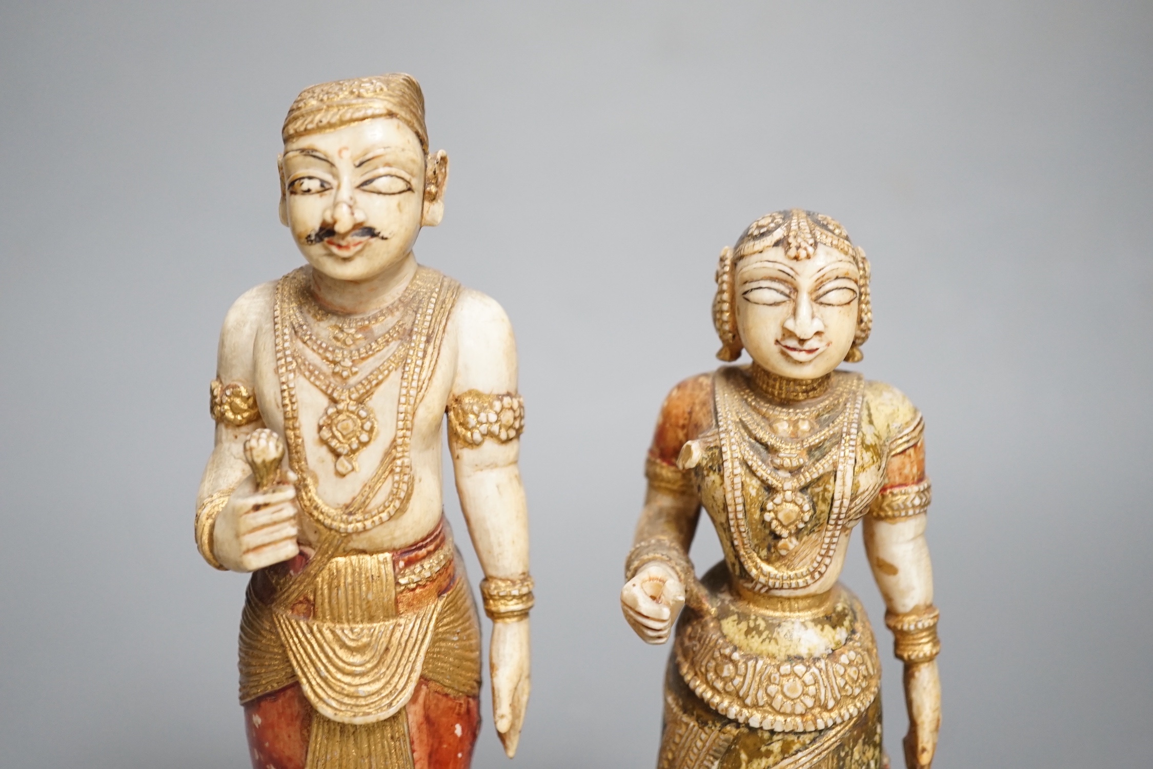 A pair of 18th century painted carved Indian ivory figures, male 7.6cm high female: 5.5cm high